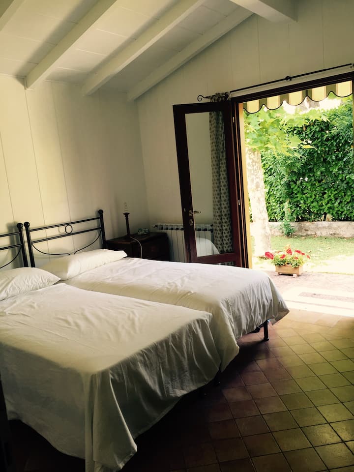 חדר שינה שני עם שתי מיטות יחיד וגישה ישירה לגינה