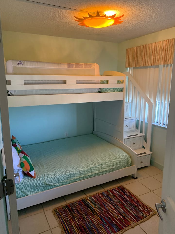 Втора спална соба со брачен кревет над полн кревет и скали до врвот. 