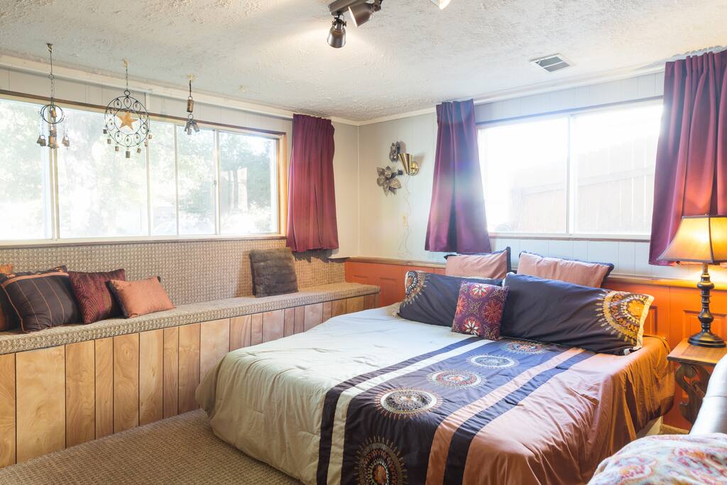 The downstairs guest suite with a king size bed and awesome orange paneling! Huge windows but the curtains are blackout so you'll get a good night's sleep!