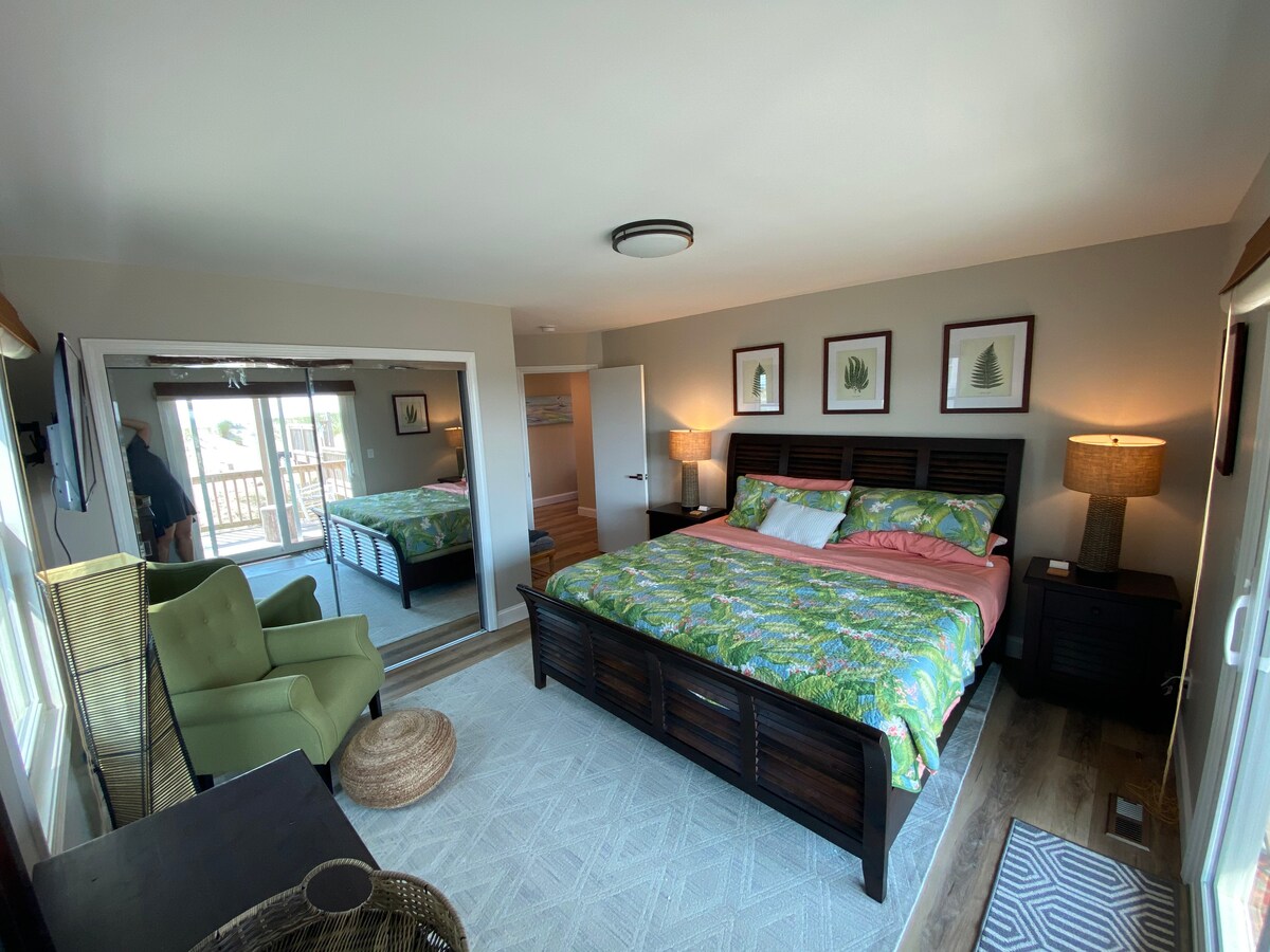 La salle botanique comprend une chaise de lecture afin que les voyageurs puissent profiter d'un moment de calme loin de leurs voyageurs lorsqu'ils ont besoin d'une pause. Le lit king size fait face au lever du soleil, assurant un début anticipé à chaque journée si vous voulez attraper les meilleurs coquillages de l'OBX