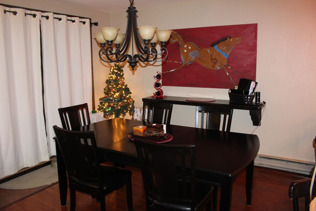 Dining room with table for six, serving sideboard and balcony with views.Dining room on main floor
