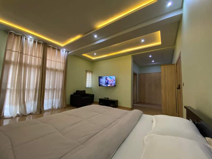 Un dormitorio principal bien iluminado con televisor inteligente TCL de 50 pulgadas para un ambiente acogedor.
