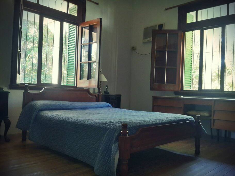 Habitación principal con cama de dos plazas, aire acondicionado, placard y amplia vista al parque.