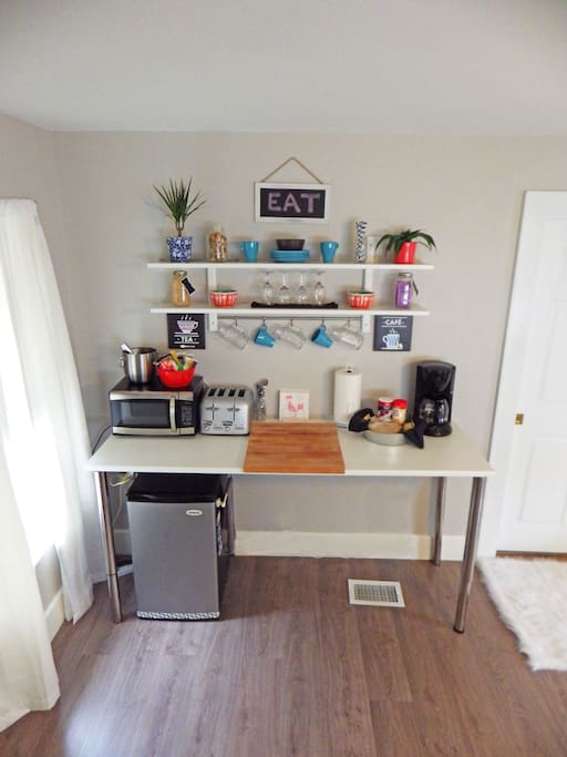Stocked kitchenette with complementary snacks and beverages.