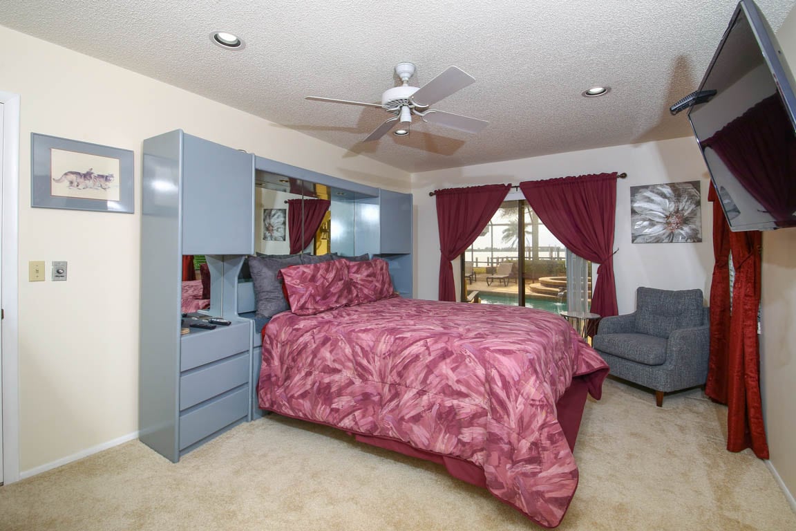 Dormitorio queen con vistas a la piscina/spa y a la bahía de Palma Sola