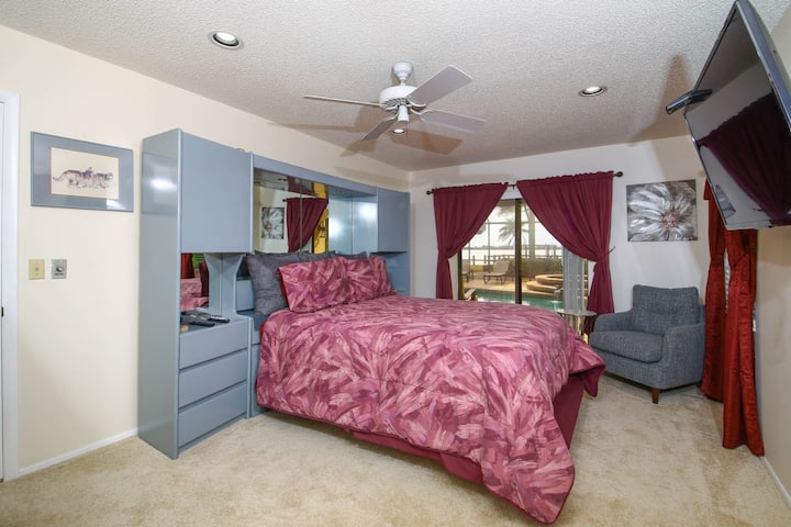 Queen bedroom with views of pool/spa and Palma Sola Bay