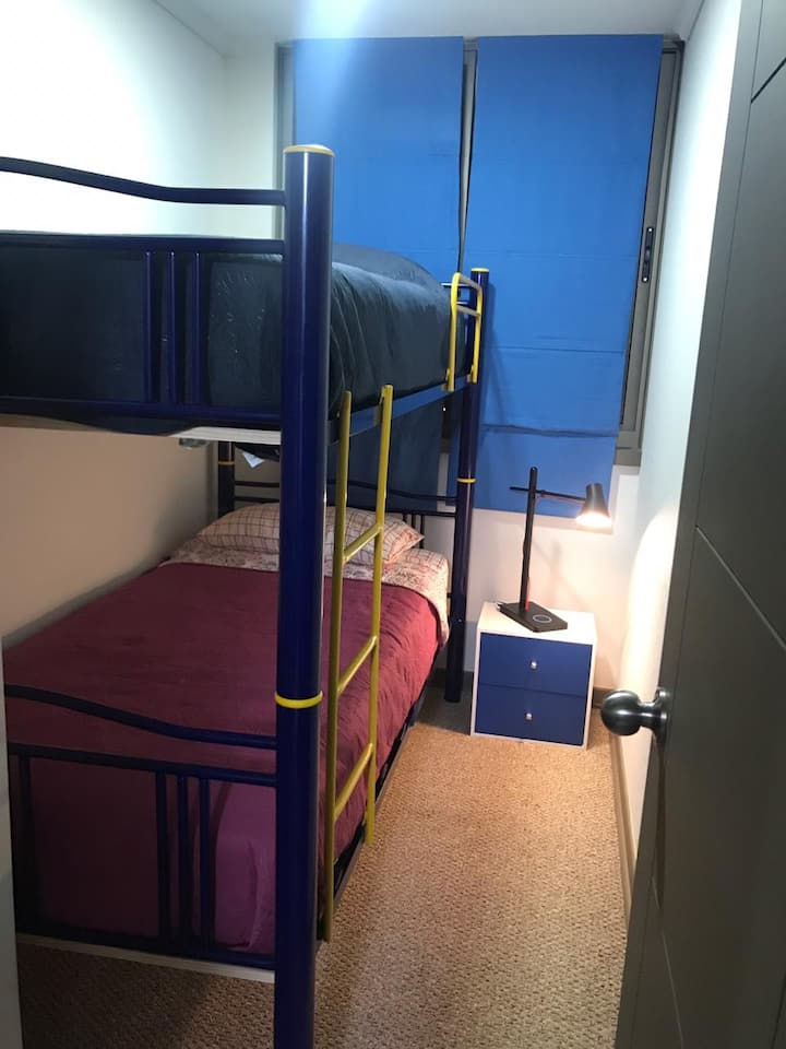 غرفة نوم صغيرة 
تشمل سريرين جديدين ونافذة
ستائر سوداء، تسمح بالظلام المطلق إذا لزم الأمر 