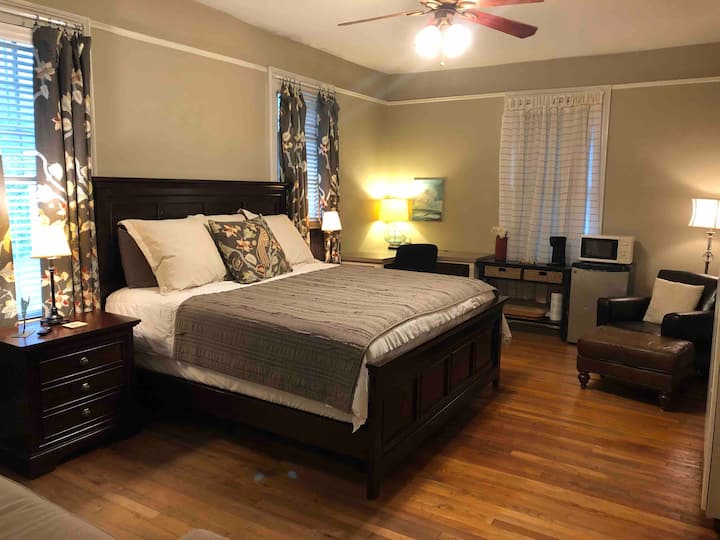 A spacious bedroom with a king size bed, with plenty of room to relax and work. 
