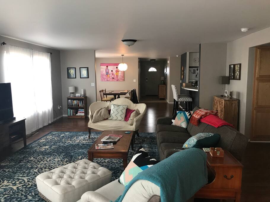 Big open floor plan with lots of natural light. Here you can see the living room, dining room, and front entry.