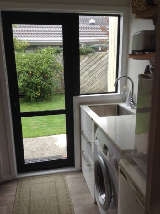 Entrance, laundry/kitchenette with sink, fridge and washing machine