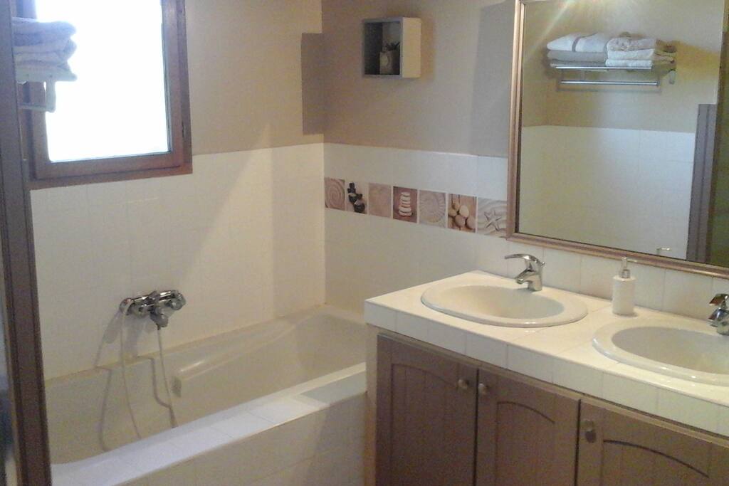 Grande salle de bain avec un coin douche + une baignoire, lavabo deux vasques .
