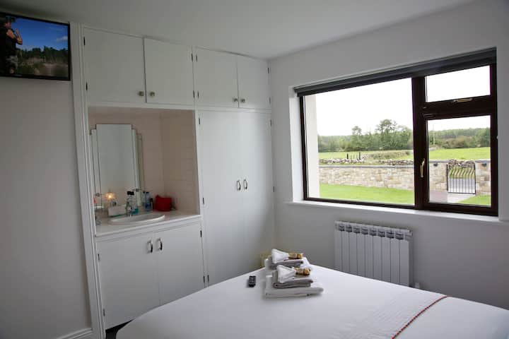 Bedroom #1 with vanity/sink & ample closet/storage space-your own personal TV. Your sheets/duvets freshly laundered-Your bed made to perfection by a master bed maker. Stunning southern views of the front lawn and our surrounding lush green fields 