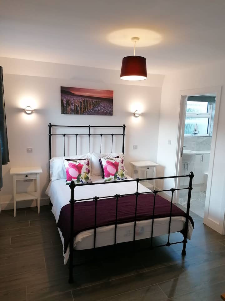 El gran dormitorio principal contemporáneo con acceso al baño en suite.