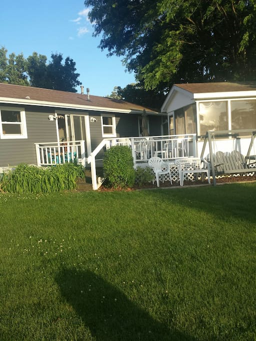 View of the back of house, deck, screen room.
