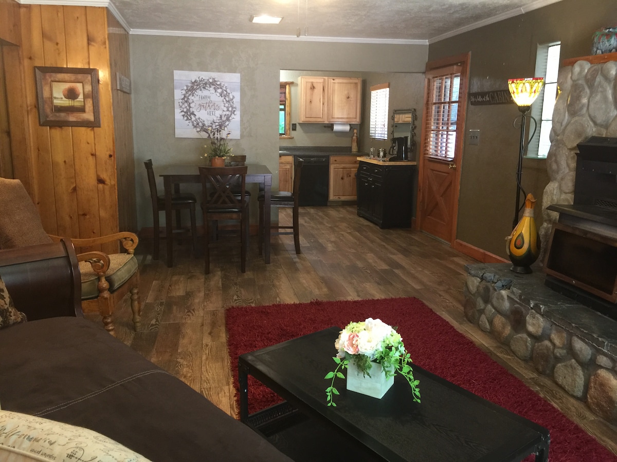 Living room has a charming river rock fireplace