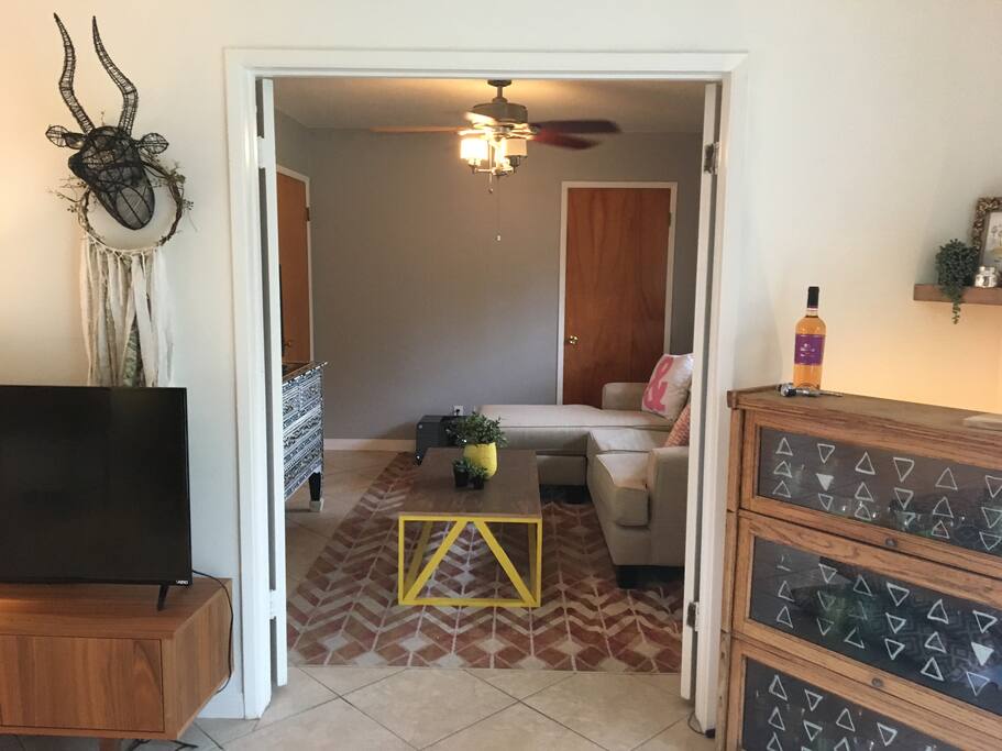 Living room opens up to the first guest room with TV