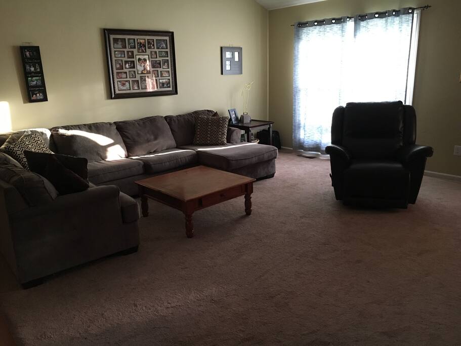 Large comfortable living room with sectional and leather recliner.
