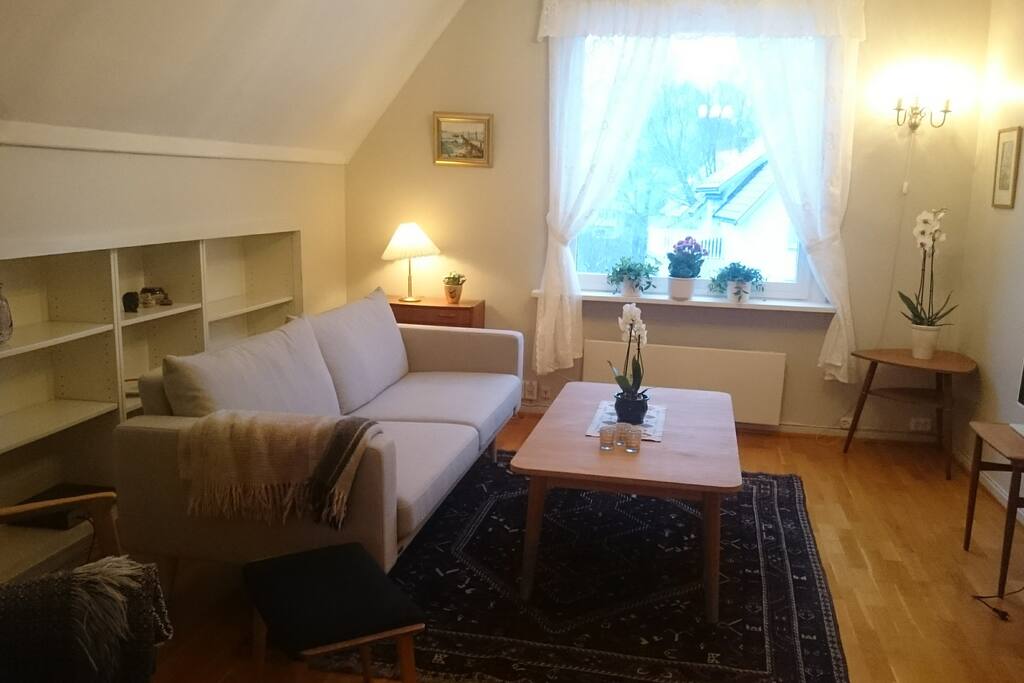 Lys stue med komfortabel sofa og TV