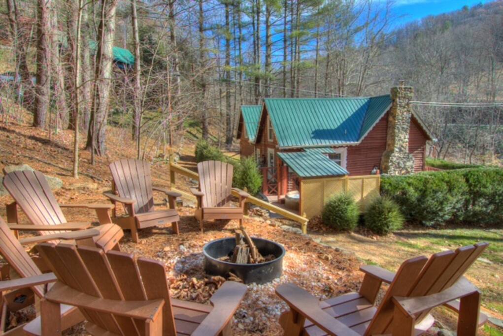 Firepit located up some stairs. There are 6 Adirondack chairs.
