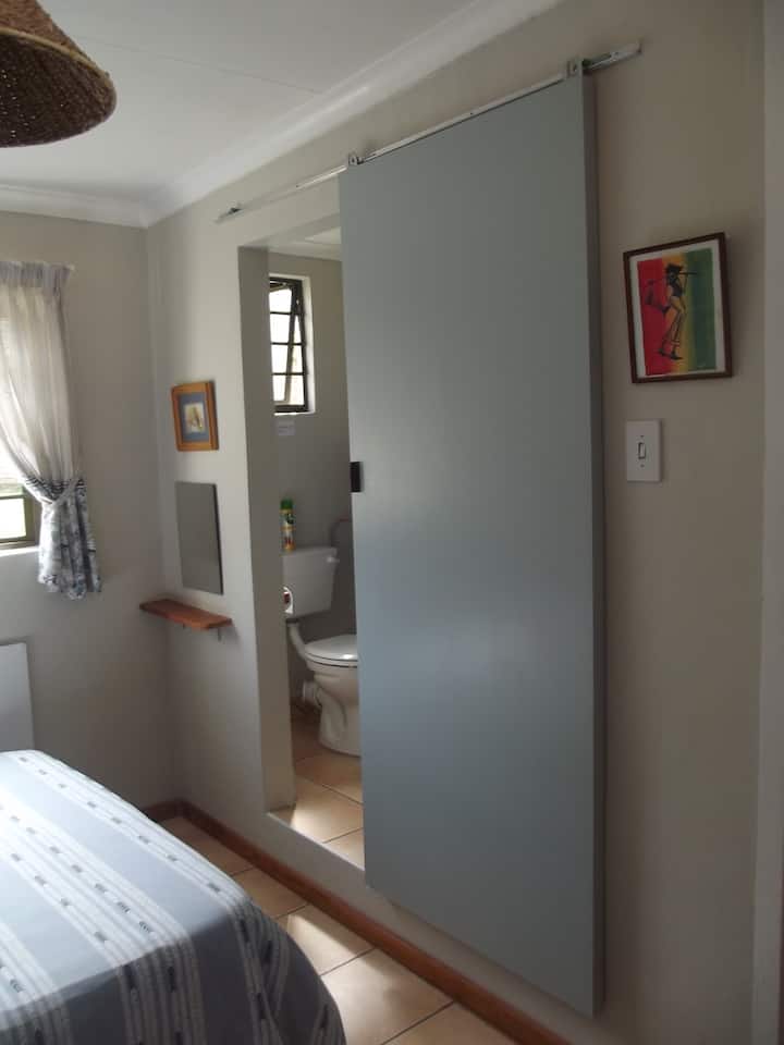 Salle de bain attenante derrière la porte coulissante pour plus d'intimité. Serviettes de toilette et gel douche liquide fournis.