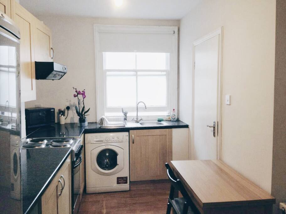 Kitchen includes ovens, microwave oven, a washing machine and a refrigerator.