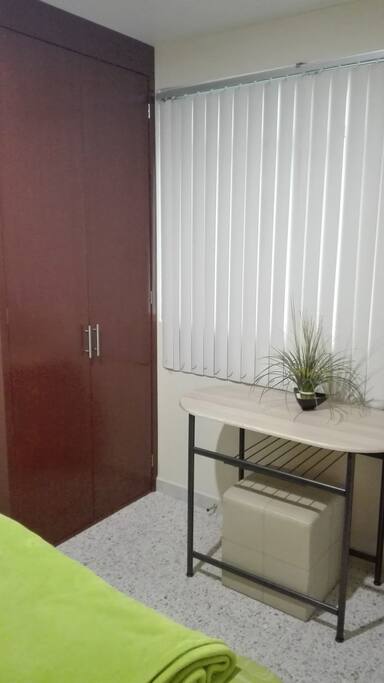 Ropero y escritorio pequeño dentro de la habitación.