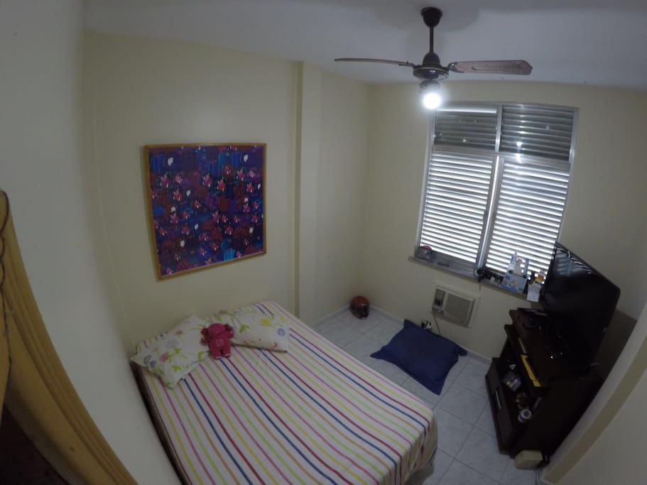 Quarto com cama de casal e televisão
