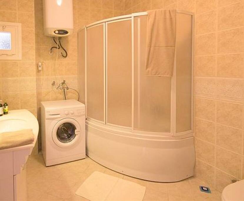 Family bathroom with corner bath, shower and washing machine