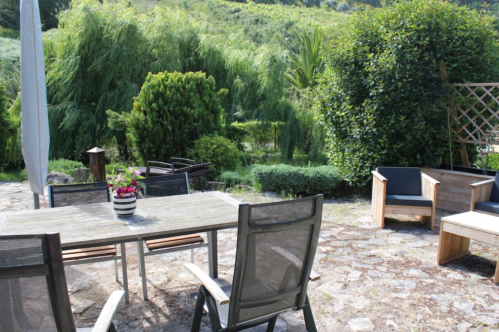 Outdoor dining area and loungeset, two sunbeds and a parasol.