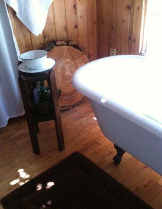 The bath house features a clawfoot tub in a sunny window.