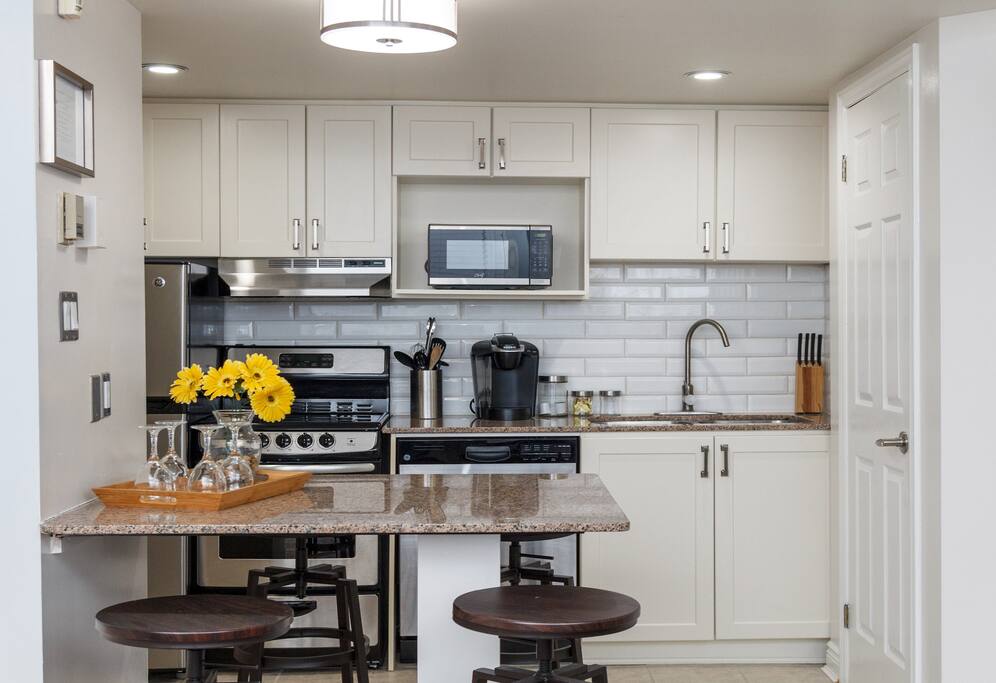 Enjoying cooking a meal in our full modern kitchen, which includes dishes, cutlery and all needed cooking utensils. With many features like our Keurig coffee maker.
