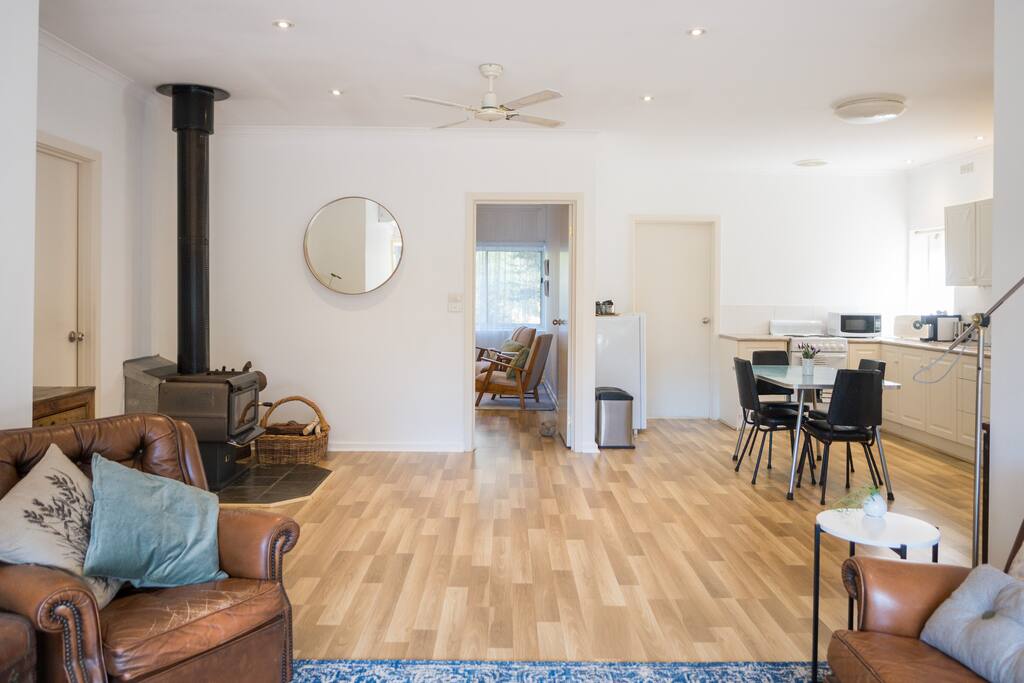 Comfortable chairs and TV in lounge, lead into the self-contained, open plan kitchen area