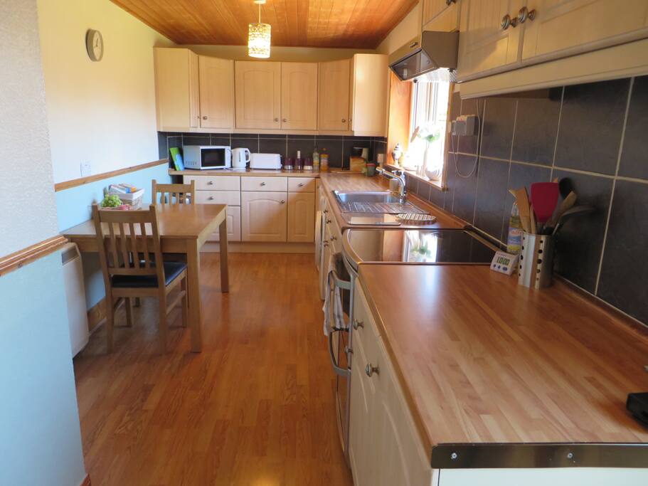 Kitchen - with washing machine, fridge and view to the back garden.