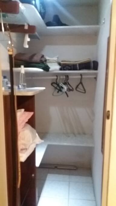 Closet com toalhas e roupagem da cama.