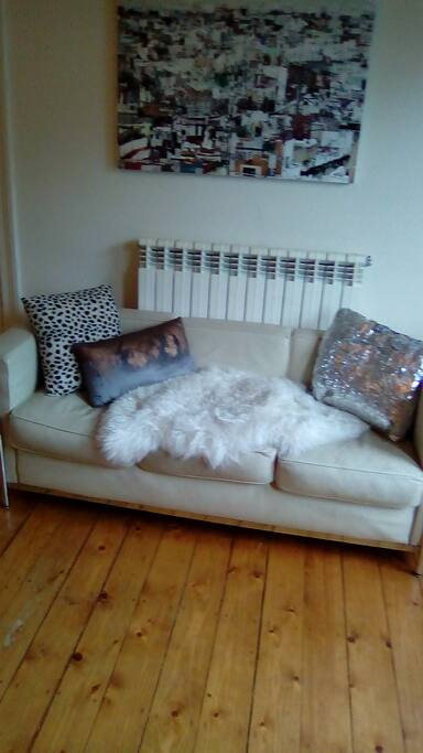 Sittingroom with simple furnishing and Modern art pieces.