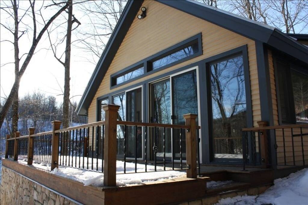 The porch comes to life in the spring with patio furniture and adirondack chairs