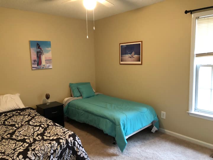 Релаксираща тематична стая на плажа с две единични легла точно до банята за гости