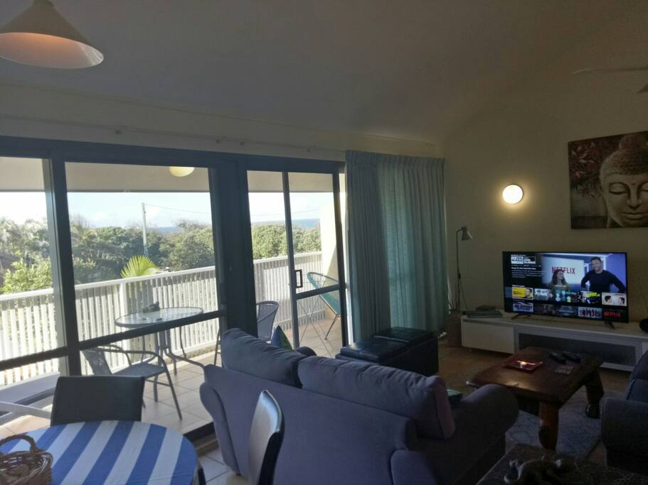Lounge room & television space opens up onto an outdoor patio area with ocean views.