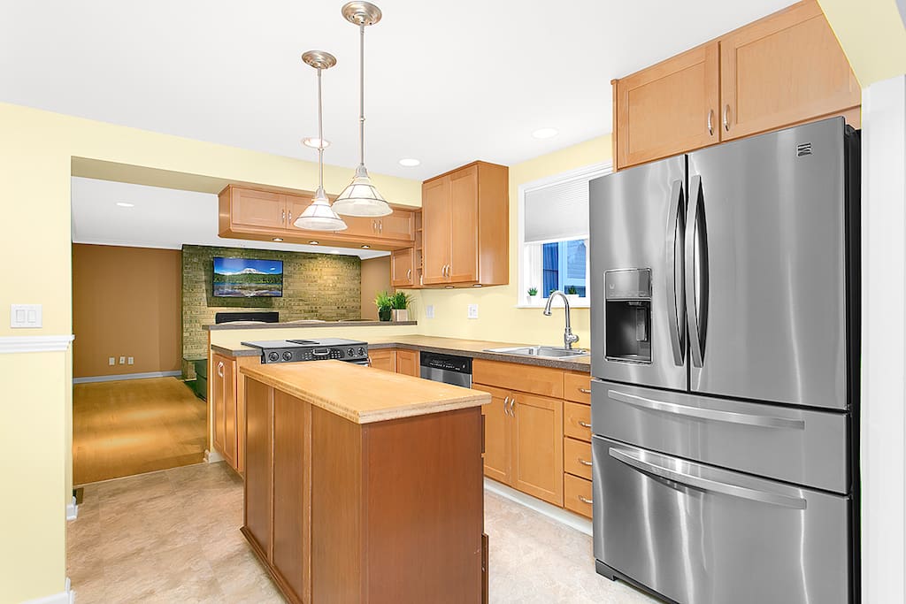 Open kitchen, including coffee maker, pots, pans and dishes.