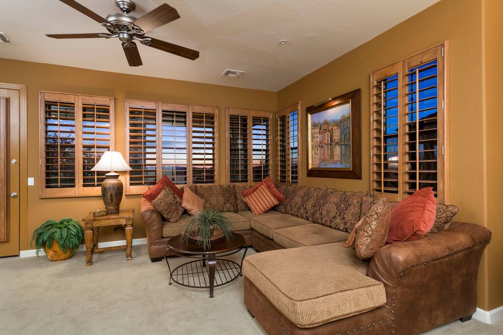 Huge wrap around windows in the living room with wood shutters in the entire unit.
