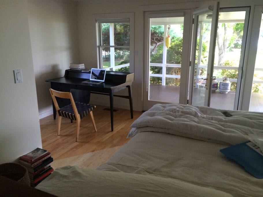 Master bedroom with king bed, desk, and bay views.