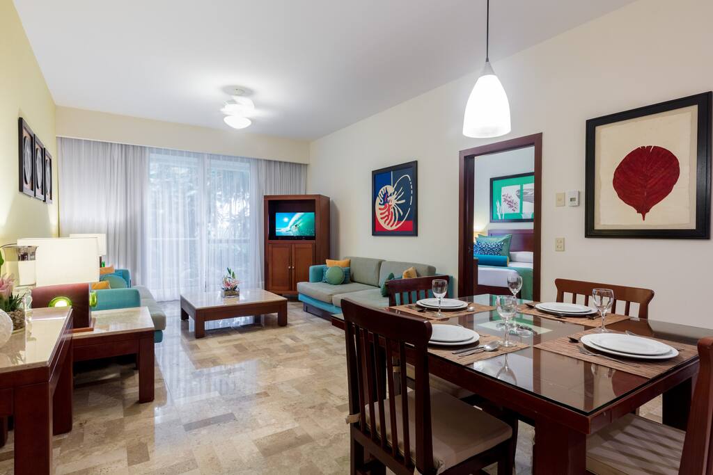 Dining set for 4 and flat screen TV in open concept living/dining area.