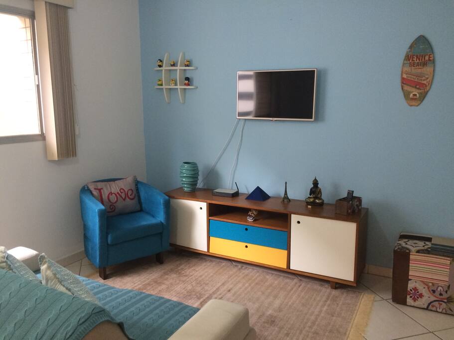Sala co, TV, internet, sofá, poltrona e puff.