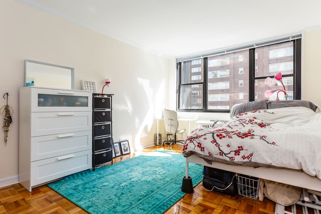 Charming bedroom with a comfortable bed, big windows, and lots of natural light