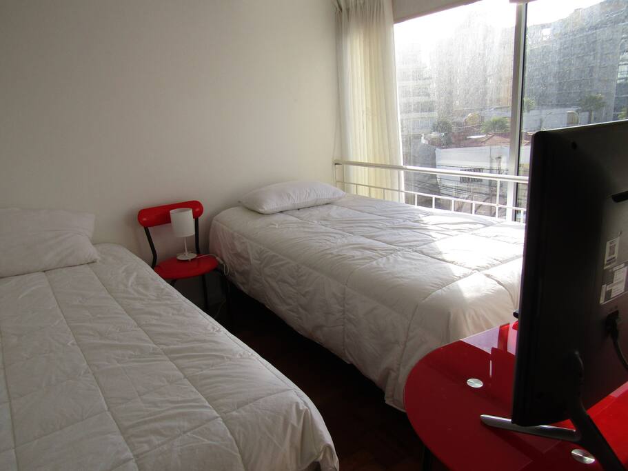 Dormitorio 1: 1 Cama de 1 plaza (twin) y 1 cama 1 1/2 plaza (full), con tv y vista a la ciudad.