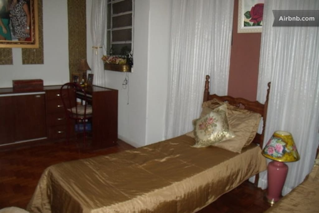 Quarto grande com piso em madeira.