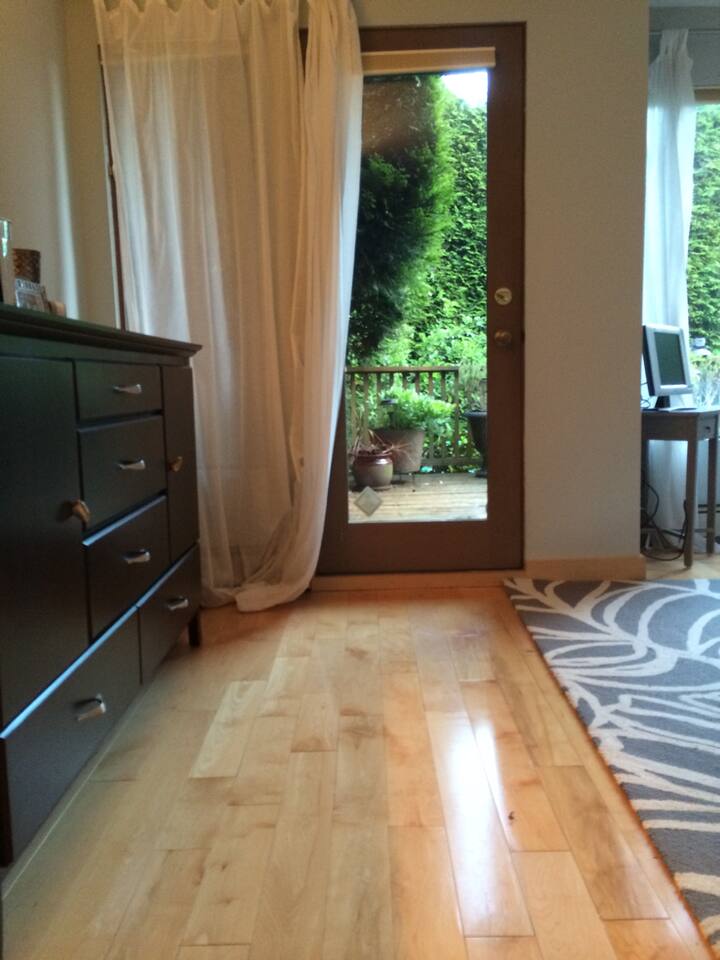 Chumba kikuu cha kulala kinachoonyesha mlango wa sitaha ya ua wa nyuma. 