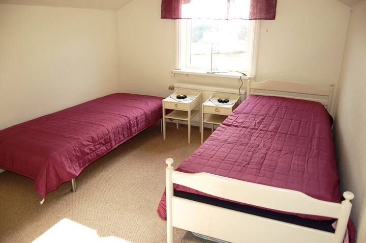 1 dormitorio con 2 camas de una plaza, cama supletoria y cuna para niños.