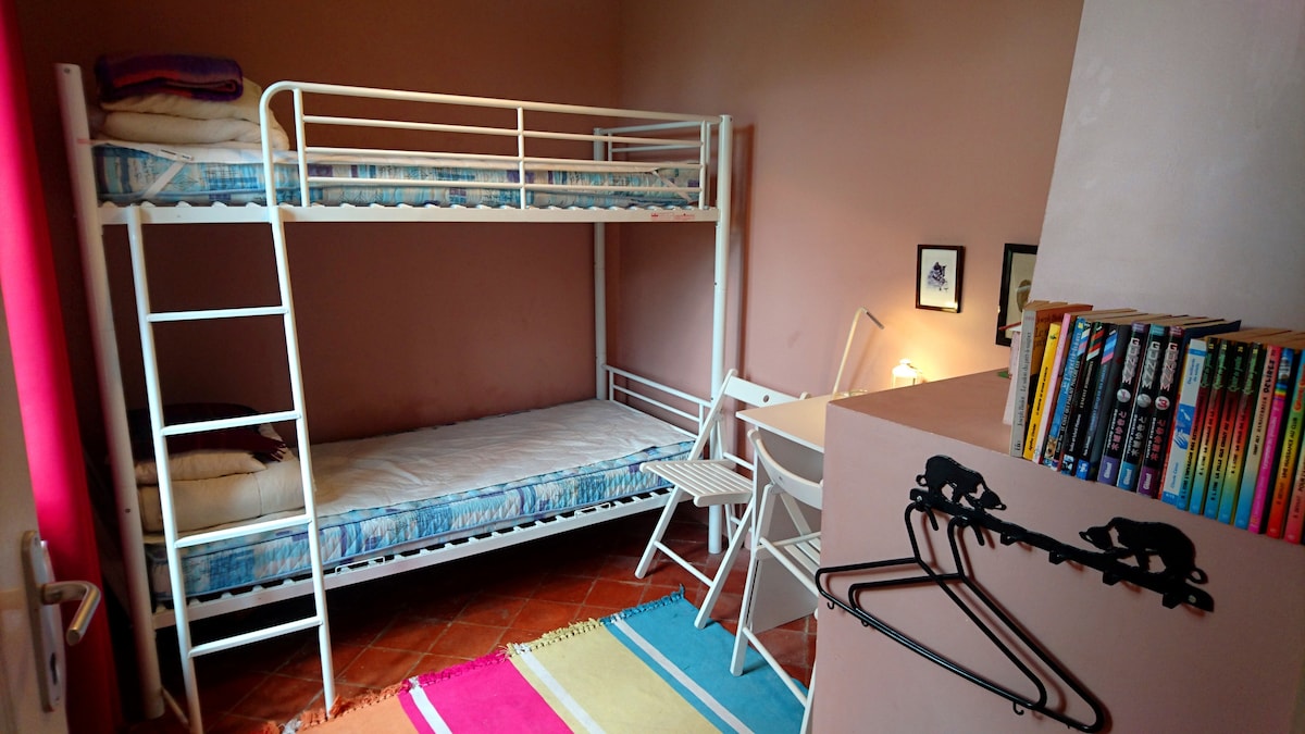 Soba na kat ima radni stol i lijep pogled na vrt