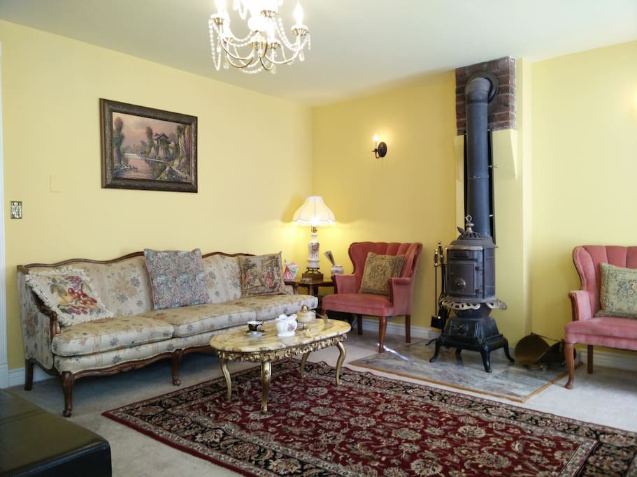 LIVING ROOM HAS A BIG FLAT SCREEN TV AND AN ANTIQUE ORIGINAL FIRE PLACE